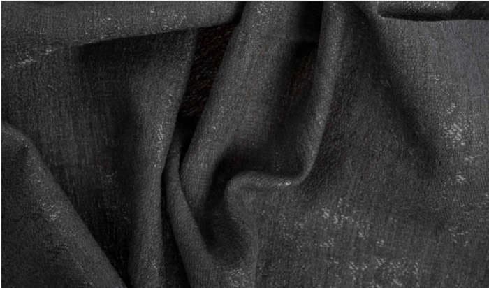 This fabric, a close-up of a dark-colored (likely black or very dark gray), slightly glossy or speckled texture, with a draped appearance, prominently displays its folds and shadows.