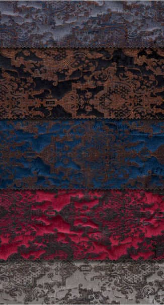Luxurious upholstery fabric samples with different background colors, a velvet-like appearance, and classic motifs embroidered on them.