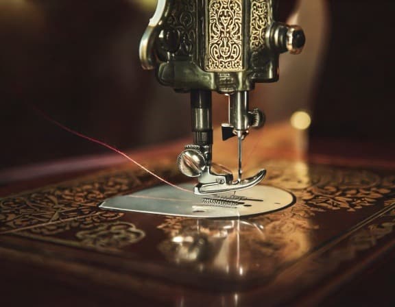 Detailed close-up of an antique sewing machine with thread.